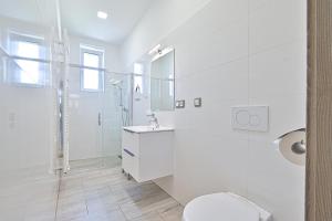 a white bathroom with a toilet and a shower at Apartmán na výsluní in Luhačovice