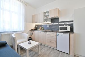 a small kitchen with a couch and a table at Apartmán na výsluní in Luhačovice