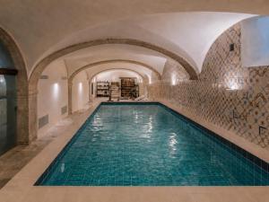 an indoor swimming pool with turquoise water at Casagrand Luxury Apartments Lisboa in Lisbon