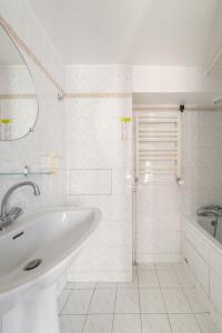 a white bathroom with a sink and a shower at Get My Hatch Bergère in Paris