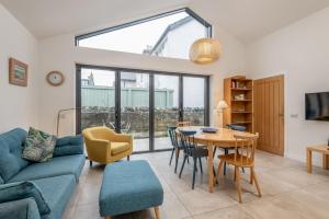 a living room with a blue couch and a table at Tylosand, Allan Place No 8 in Earlsferry