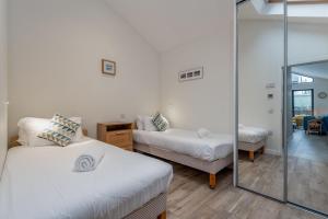 a room with two beds and a mirror at Tylosand, Allan Place No 8 in Earlsferry