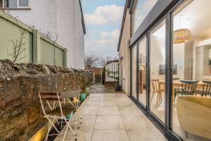 a patio with a stone wall and a bench at Tylosand, Allan Place No 8 in Earlsferry