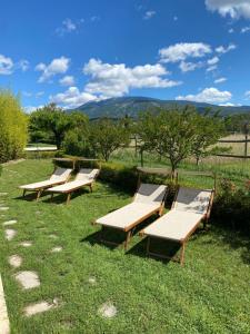 a row of wooden benches sitting in the grass at Mas de grange neuve in Mollans-sur-Ouvèze