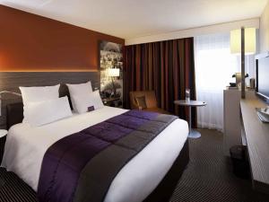 a hotel room with a large bed and a television at Mercure Chambéry Centre in Chambéry +52 photos