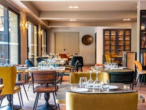 a restaurant with tables and chairs in a room at Mercure Carcassonne La Cité in Carcassonne