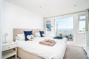 a bedroom with a white bed and a window at Jan Dee Cottage in Ventnor