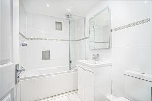 a white bathroom with a sink and a shower at Jan Dee Cottage in Ventnor +36 photos