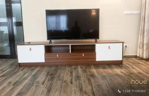 a flat screen tv sitting on top of a entertainment center at Résidence Houé in Lomé