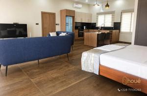 a bedroom with a bed and a living room and a kitchen at Résidence Houé in Lomé