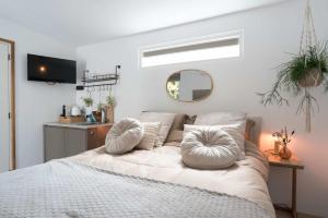 a bedroom with a bed with pillows and a mirror at Ben Thuis Studio Alkmaar in Alkmaar