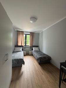 a bedroom with two beds and a window at Horiza Białe Błota in Białe Błota