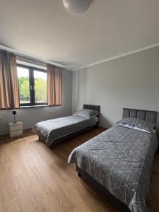 a bedroom with two beds and a window at Horiza Białe Błota in Białe Błota +13 photos