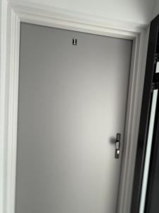 a white door with a silver handle in a room at Horiza Białe Błota in Białe Błota