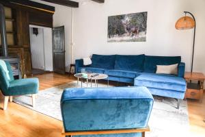 a living room with a blue couch and chairs at Maison Ainvelle - with Sauna in Ainvelle