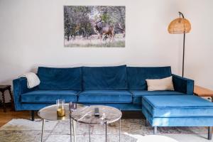 a living room with a blue couch and a table at Maison Ainvelle - with Sauna in Ainvelle