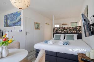 a bedroom with a large white bed with blue pillows at The New Lake Boathouse in Amsterdam