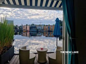 a patio with a table and a blue umbrella at The New Lake Boathouse in Amsterdam
