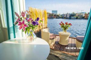a table with two vases of flowers on a boat at The New Lake Boathouse in Amsterdam