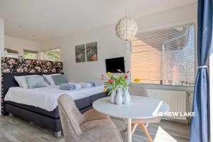 a bedroom with a bed and a table with flowers at The New Lake Boathouse in Amsterdam