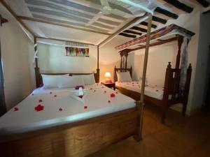 a bedroom with two beds with flowers on them at Zuri Sana Beach Hotel in Kepwani