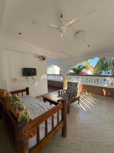 a bedroom with a bed and a balcony with a tv at Villa Tuffah in Watamu