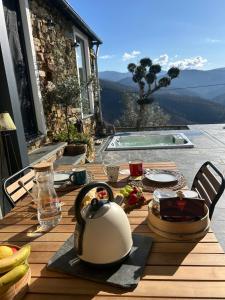 a table with a tea kettle on a table with a view at Casinha Serabigoes Arouca Passadiços Paiva in Arouca