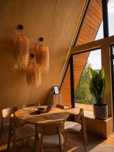 a dining room with a table and a large window at Dilok Hills in Mykulychyn