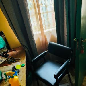 a black chair sitting in front of a window at Shalompalace in Luanda