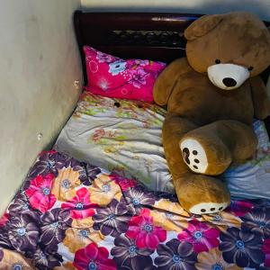 a teddy bear sitting on top of a bed at Shalompalace in Luanda