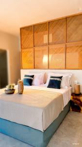 a bedroom with a large bed with white sheets and blue pillows at Porto Paradiso Seaside Resort in Vromolimnos