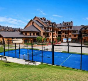 a tennis court in front of a building at La Splaza Home in Pian Camuno
