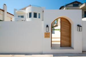 a white house with a wooden door in front at Villa Rhodea in Ialysos