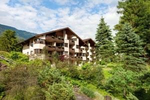 a building on the side of a hill with trees at Dorint Sporthotel Garmisch-Partenkirchen in Garmisch-Partenkirchen