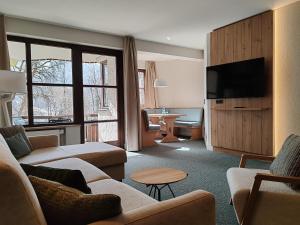 a living room with couches and a flat screen tv at Dorint Sporthotel Garmisch-Partenkirchen in Garmisch-Partenkirchen