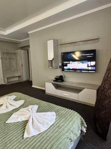 a hotel room with a bed with a flat screen tv at Garnet hotel in Bishkek
