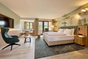 a hotel room with a bed and a chair at Dorint Sporthotel Garmisch-Partenkirchen in Garmisch-Partenkirchen +77 photos