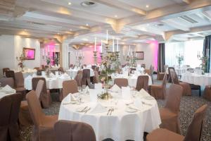a banquet room with white tables and chairs at Dorint Sporthotel Garmisch-Partenkirchen in Garmisch-Partenkirchen