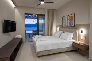a bedroom with a large bed and a television at Zoe Sea View Villas in Paleros +51 photos
