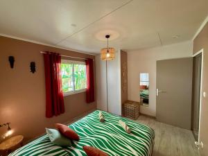 a bedroom with a bed and a window at Bungalow Tec-Tec Proche plage et centre Saint Leu in Saint-Leu