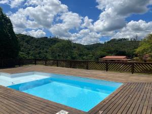 a swimming pool on top of a wooden deck at Chácara sabor de Mel in Ibiúna