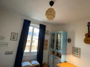 a room with blue curtains and a window with a guitar at Baia Serena in Sestri Levante