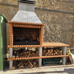 a wooden bench sitting next to a pile of logs at Casa Rural El Jaral in Orihuela del Tremedal +20 photos
