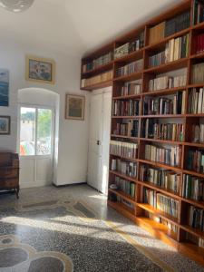a library with wooden shelves filled with books at Baia Serena in Sestri Levante