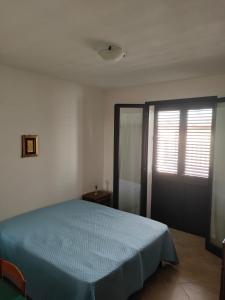 a bedroom with a blue bed and a window at Villa Cristina in Triscina