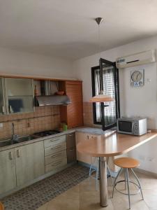 a kitchen with a wooden table and a table and a microwave at Villa Cristina in Triscina