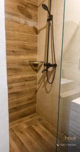 a shower with a glass door and a wooden floor at Résidence Houé  +15 photos