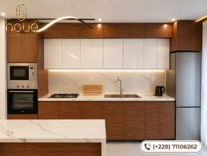 a kitchen with wooden cabinets and a sink and a refrigerator at Résidence Houé 
