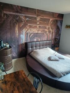 a bedroom with a large bed and a table at Chambre d'hôtes "Sur la route des Terrils" in Vendin-le-Vieil