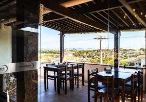 a restaurant with tables and chairs and a large window at Arambare Buzios Hotel in Búzios